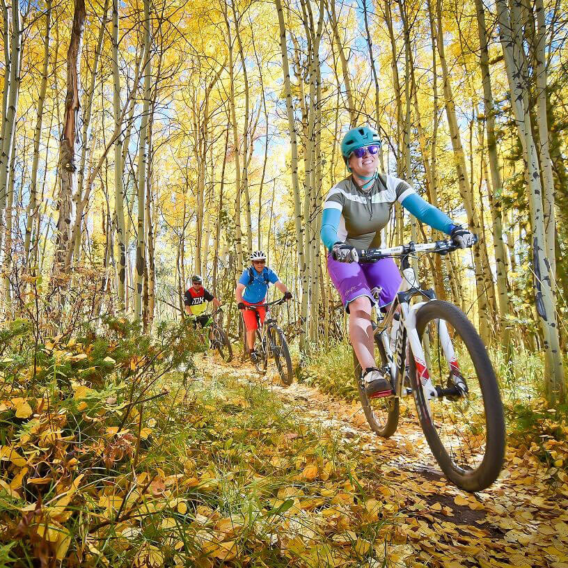 Mountain biking through aspen forest at Granby Ranch